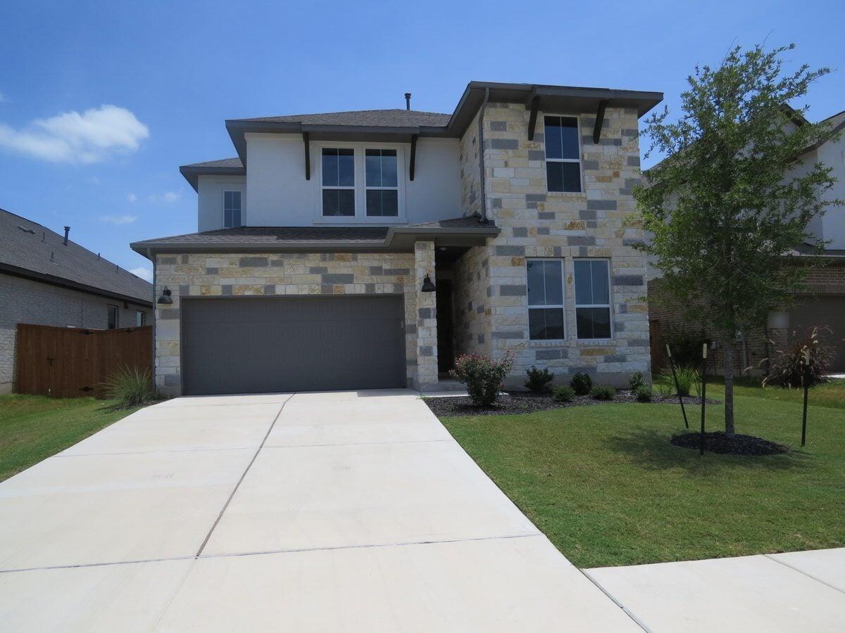 Well-kept two-story stone and stucco rental home with a manicured front yard in Killeen, Texas